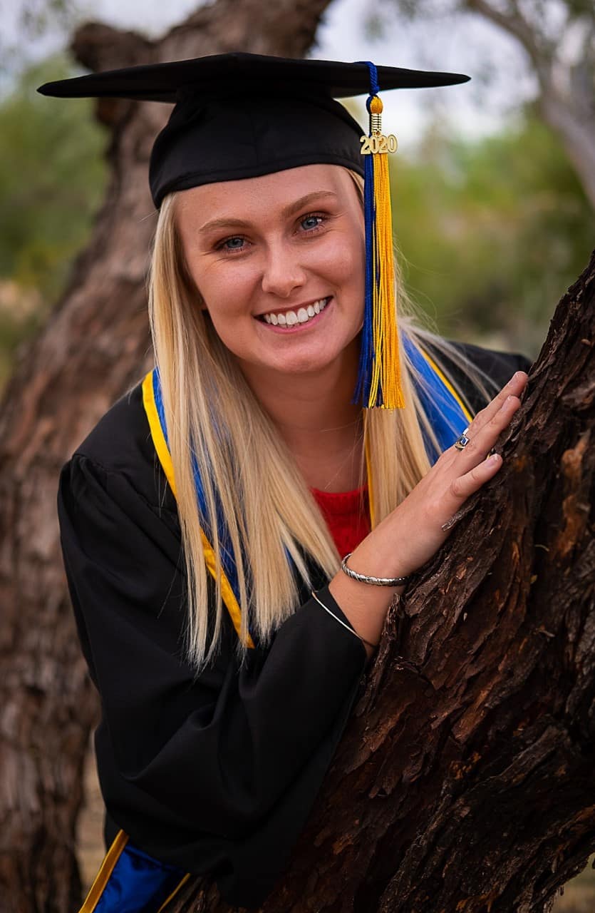 Paige Swenson wearing her graduation robes and cap.