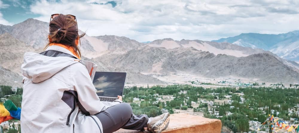 a woman studying on a rock