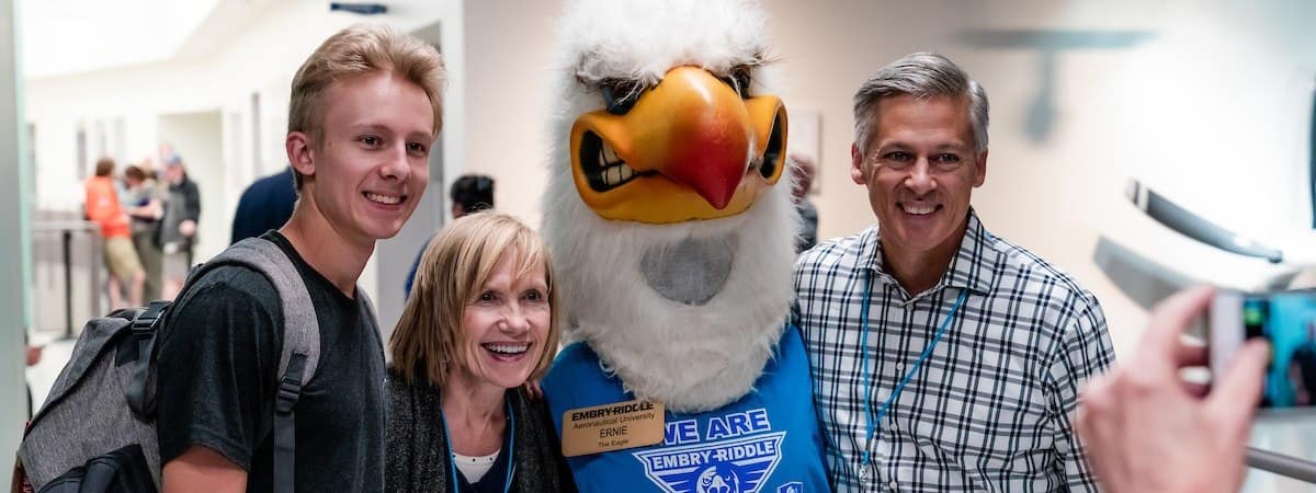 A student and their family meeting Ernie the Eagle on campus