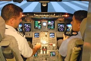 A student and instructor sit in the simulated cockpit of a Level D CRJ-700 Regional Jet Simulator at Embry-Riddle Aeronautical University's Prescott campus