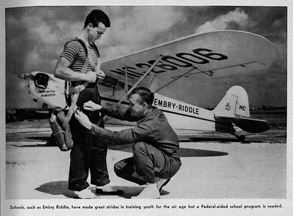 Photo shows an instructor helping a student buckle into a parachute. The caption reads: Schools, such as Embry-Riddle, have made great strides in training youth for the air age, but a Federal-aided school program is needed.