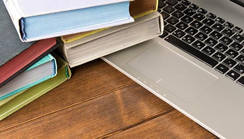 Books on top of a laptop