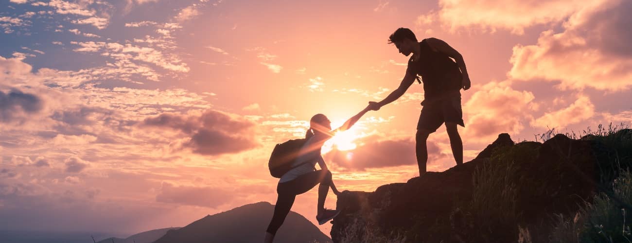 two people climbing a mountain