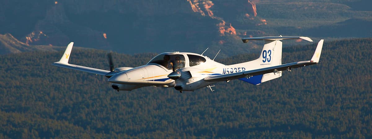 An Embry-Riddle Aeronautical University plane flies over the mountains in Prescott, Arizona.
