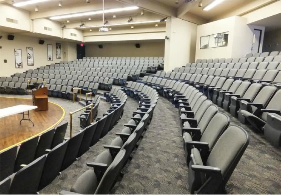 DLC Auditorium, featuring stadium seating, stage, retractable large screen for projector demonstrations