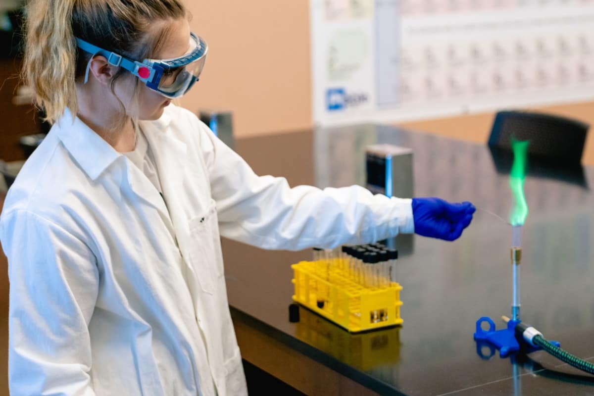 A student conducts an experiment using Chemistry lab equipment