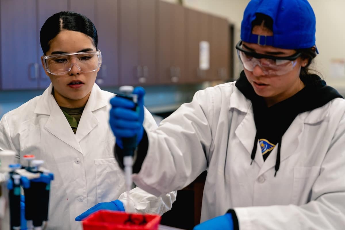 Two students conduct an experiment using equipment in the Forensic Lab
