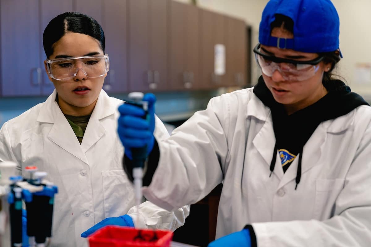 Two students conduct an experiment using equipment in the Forensic Lab