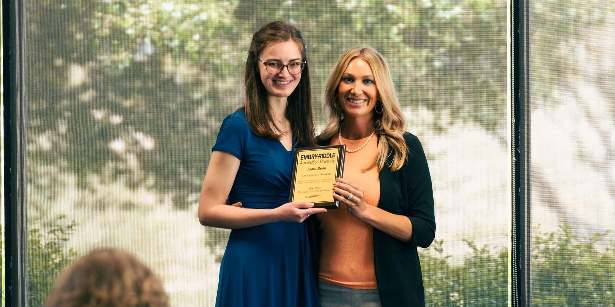 Kiara Bean (left) accepting her Distinguished Graduate Award from Samantha Friedlan, instructor of business, at the College of Business, Security & Intelligence on Embry-Riddle's Prescott Campus. (Photo: Embry-Riddle / Connor McShane)
